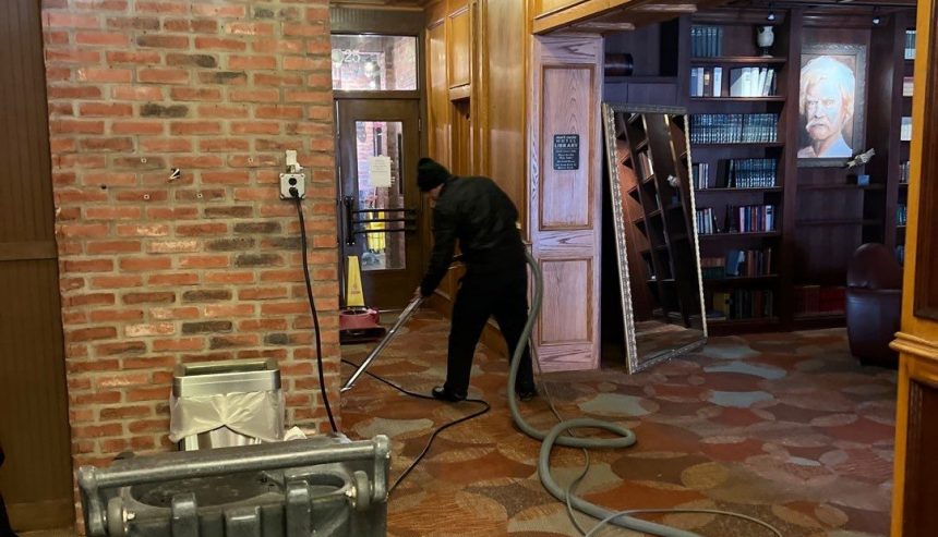 Man sweeping up water |  water damage restoration in jamestown va
