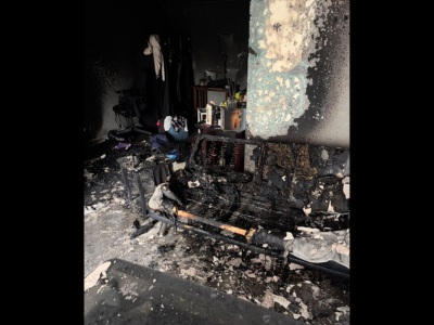 Severe interior fire and smoke damage in a living room with charred furniture and walls, showing the urgent need for expert smoke damage restoration.