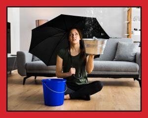 women sitting in a living room with an umbrella in her hand and a bucket of water beside her