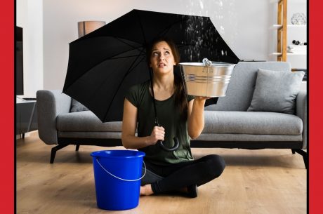 women sitting in a living room with an umbrella in her hand and a bucket of water beside her