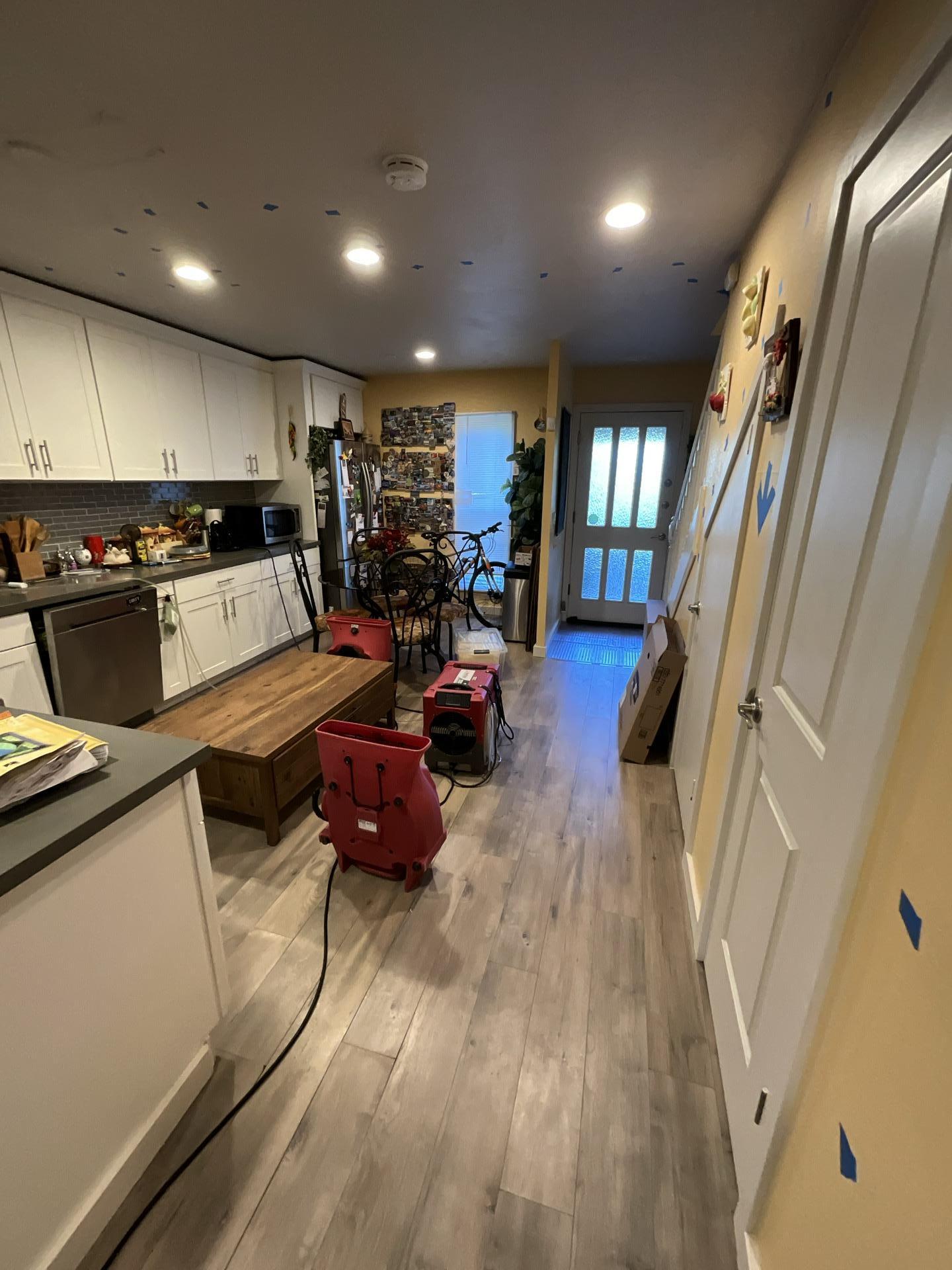 Kitchen with water damage restoration equipment after supply line leak