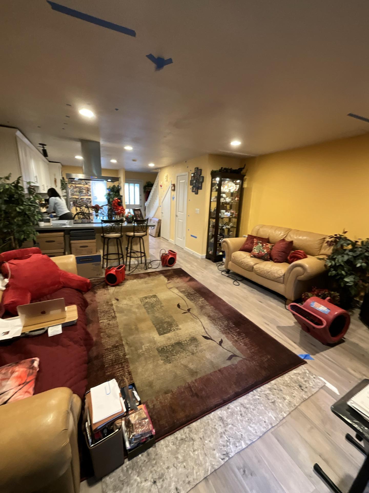 Main floor living room with industrial air movers during water damage restoration
