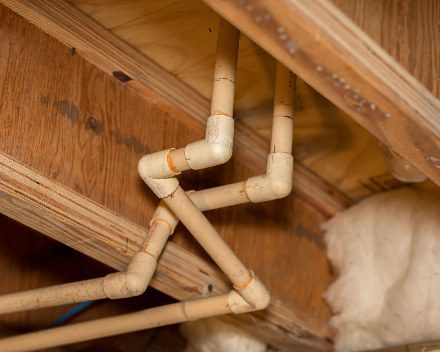 Plumbing pipes running through a residential crawl space