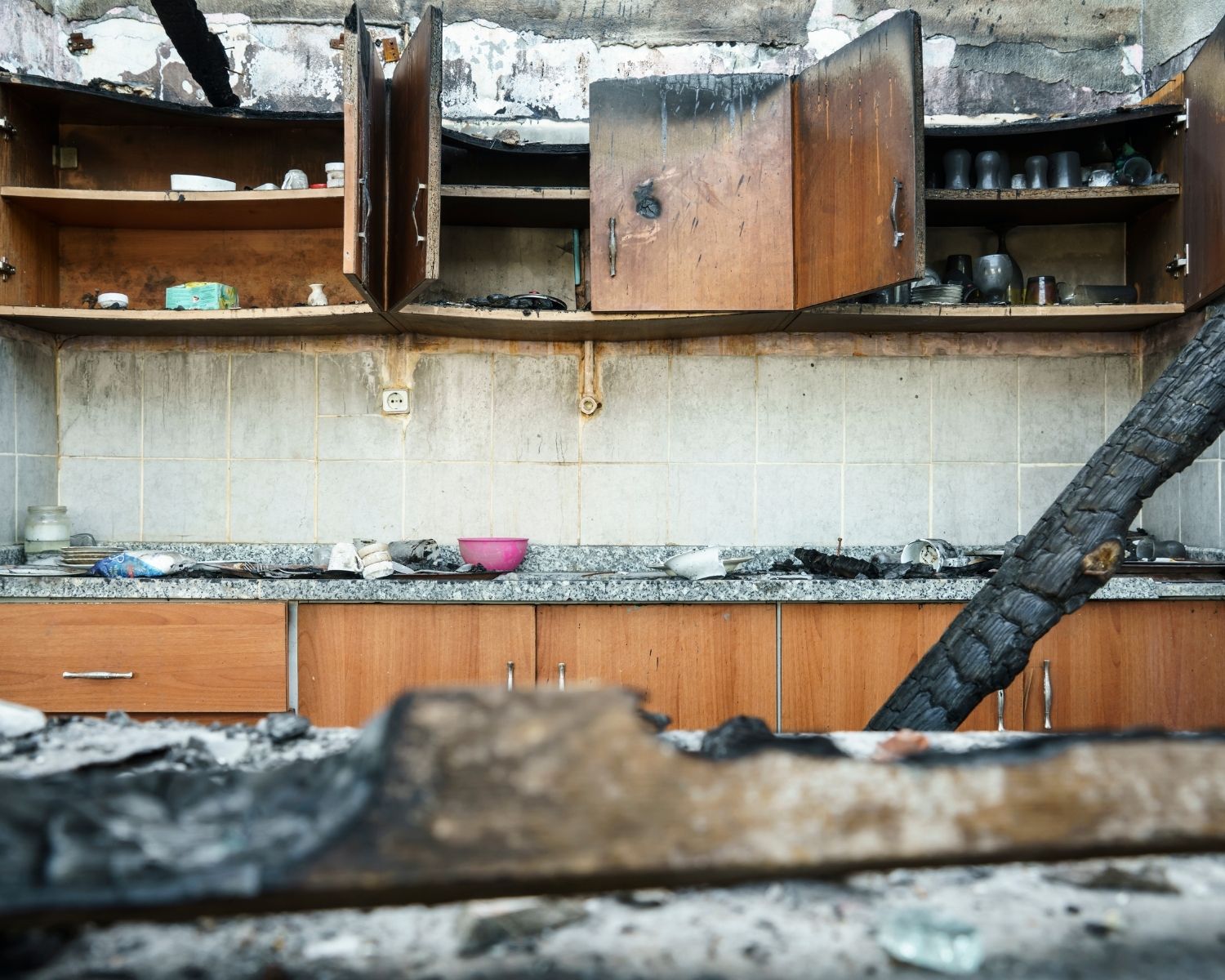 Damaged kitchen cabinets showing soot and smoke residue