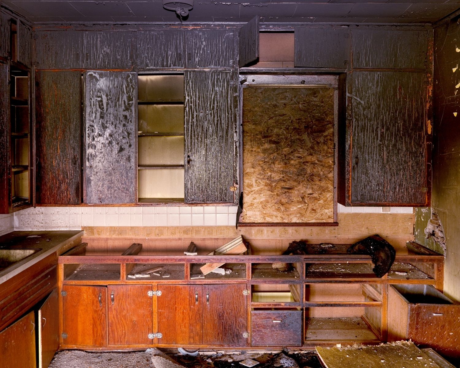 Fire damaged kitchen with visible smoke damage and soot residue