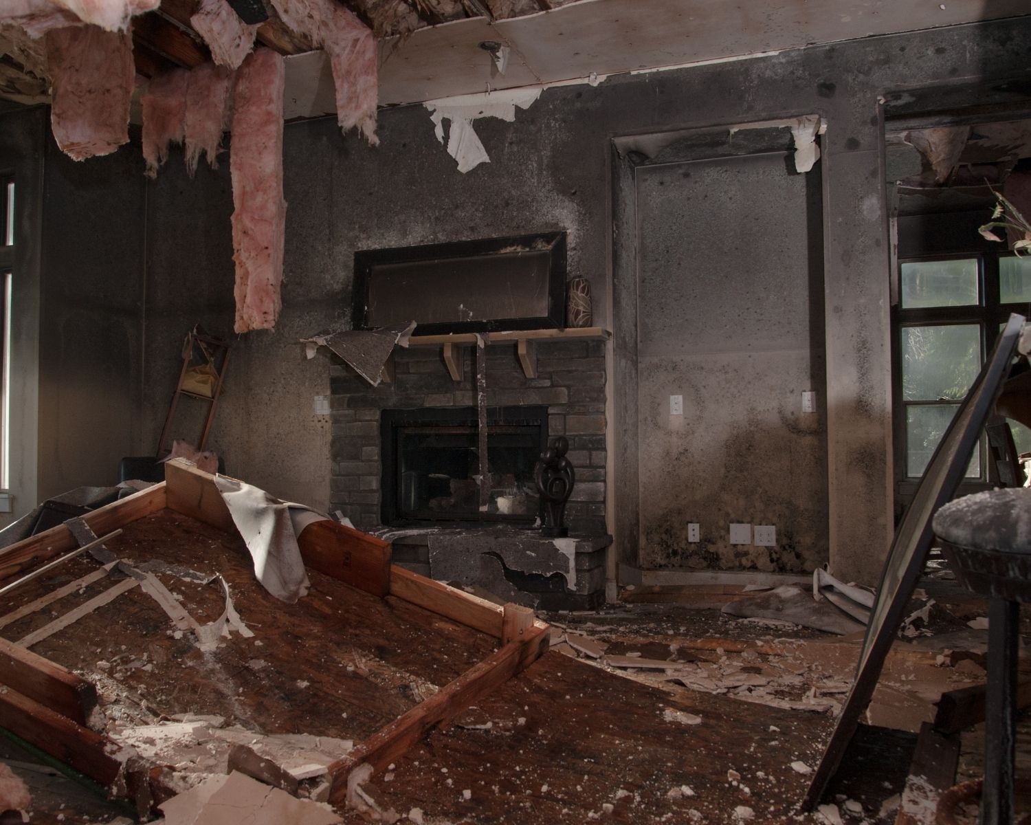 Living room with fireplace fire damage showing debris and soot