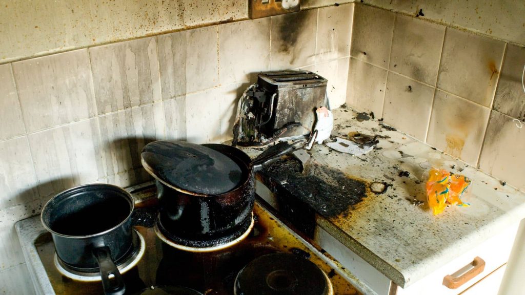 fire-damaged kitchen interior in a Snohomish home with visible soot on cabinets and ceiling