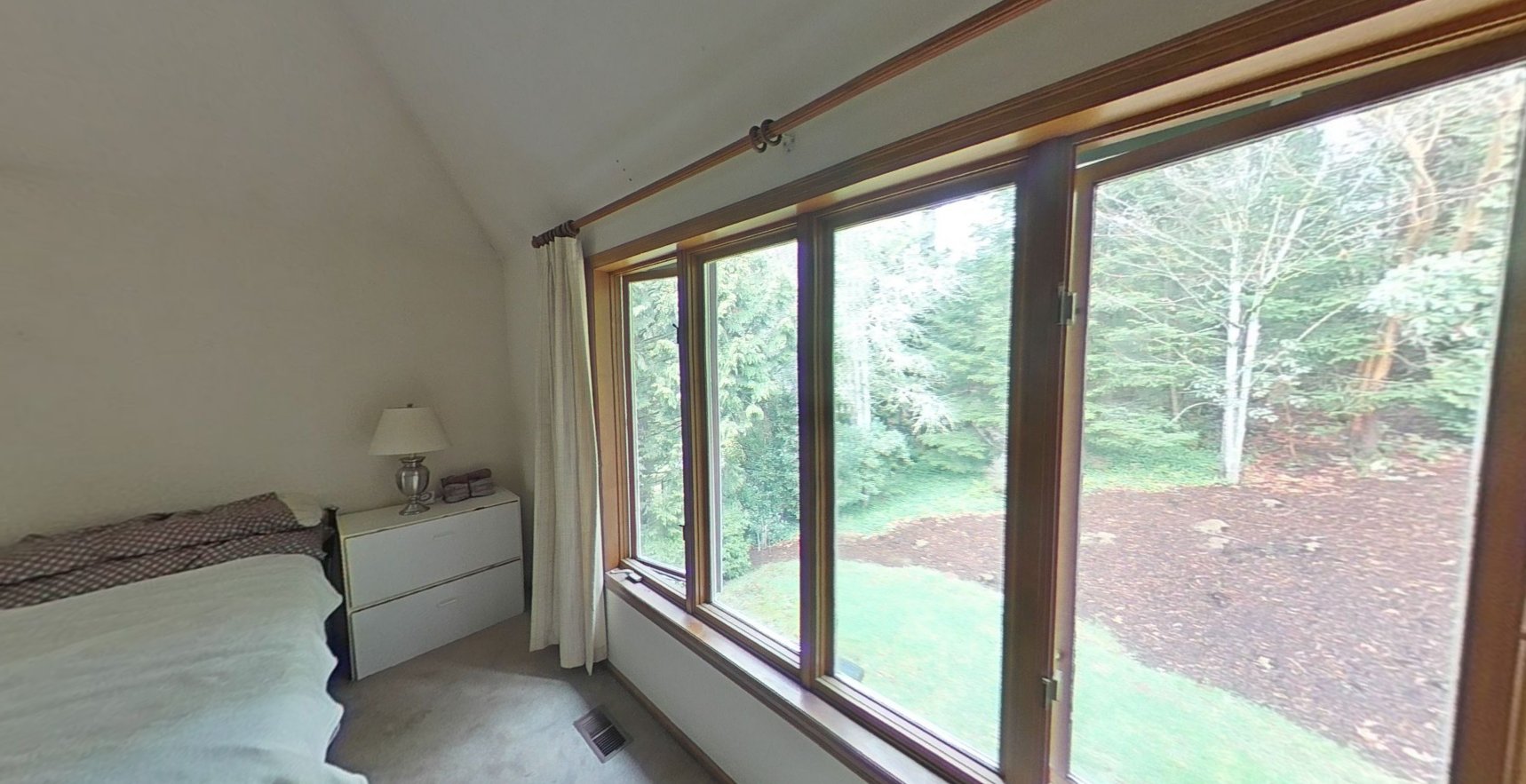 Guest bedroom with large windows and wooded lot view after ABC powder cleanup