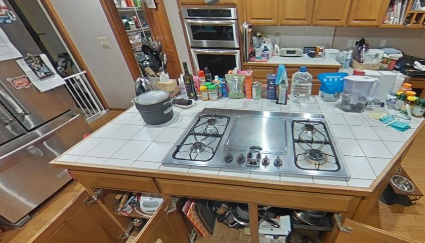 Kitchen island with gas cooktop and open lower cabinets during cleaning