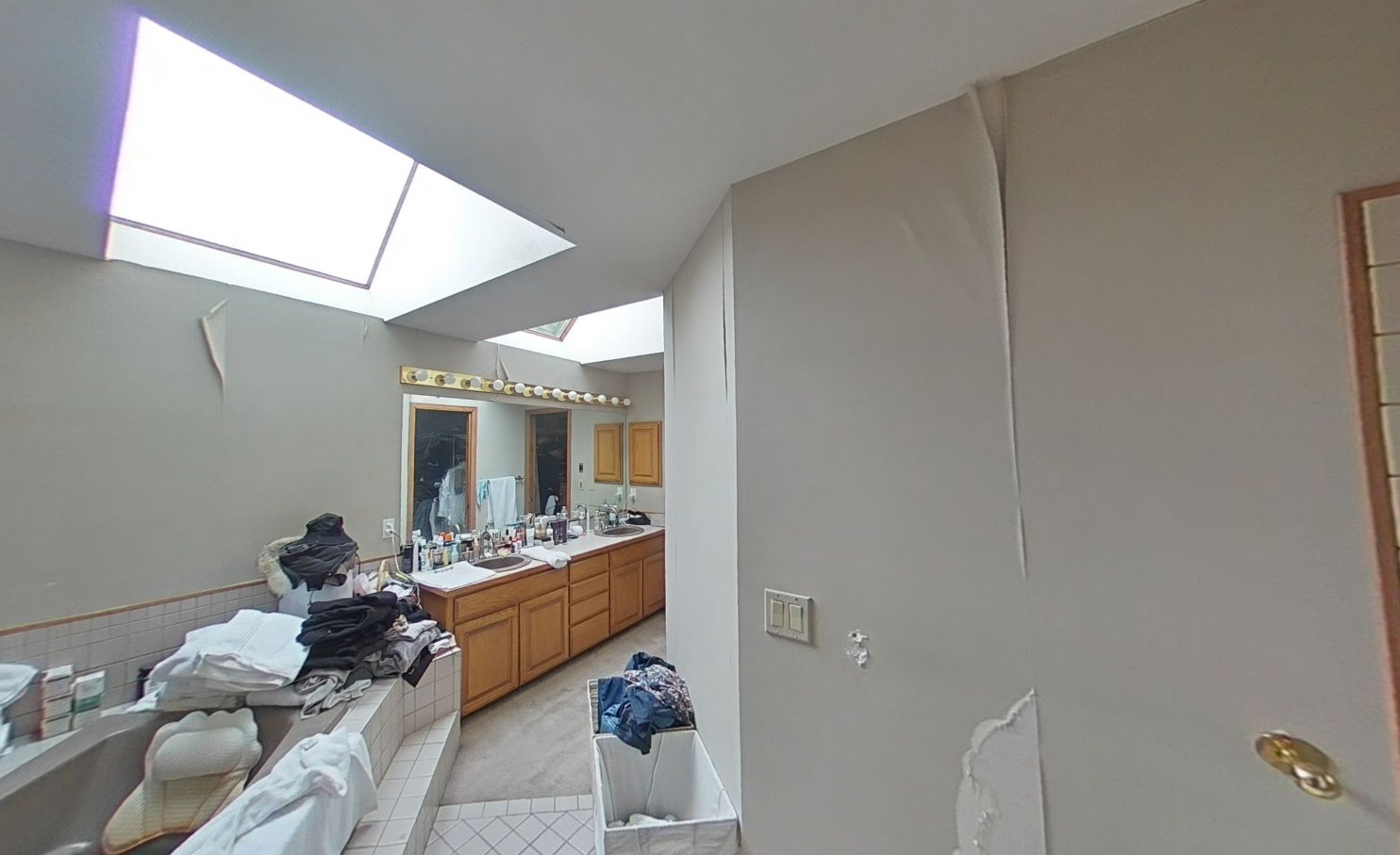 Wide view of master bathroom showing skylight, dual vanity, and ABC powder residue