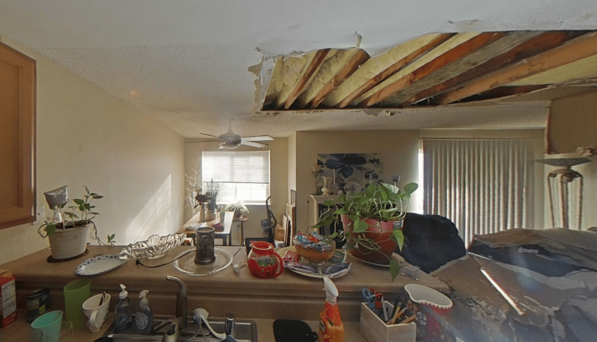 Kitchen-facing view of the damaged ceiling with exposed joists and insulation after the explosion above.