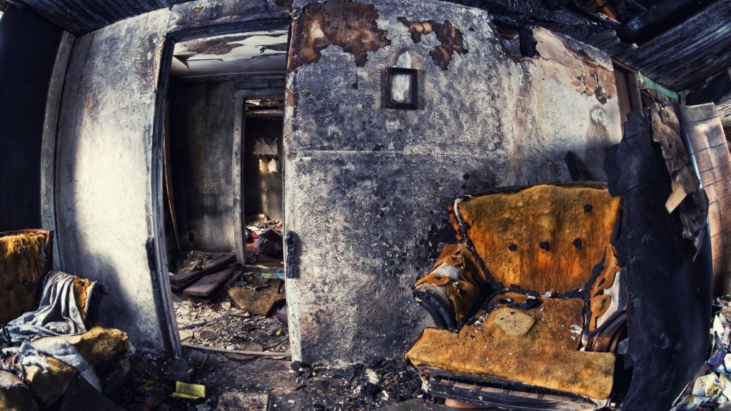 soot-stained ceiling and wall corner showing smoke spread beyond the fire source