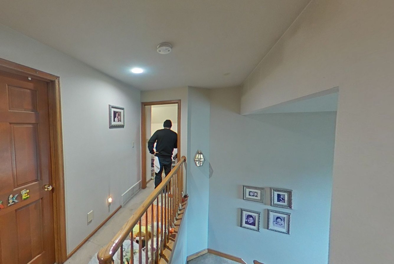 PuroClean technician performing onsite assessment in upper hallway and stairway