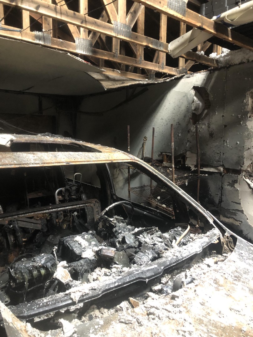 Burned vehicle inside a fire gutted residential garage in Everett, WA