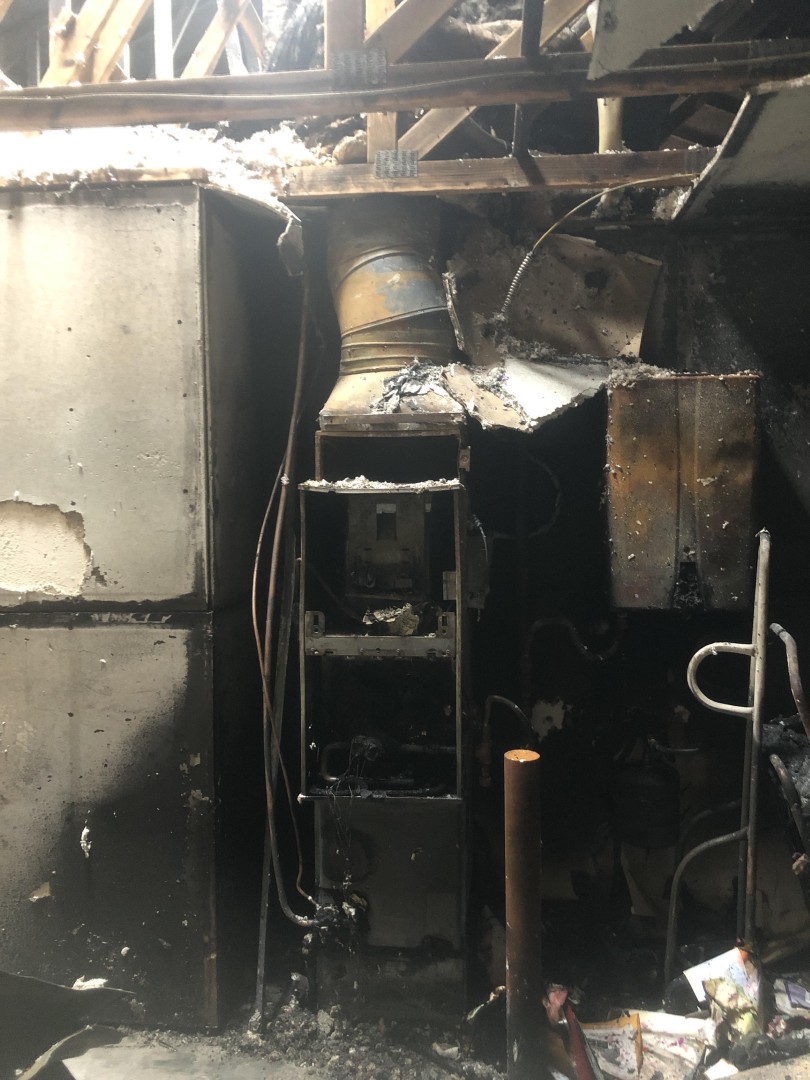 Charred garage utility wall and furnace where the electrical fire likely started
