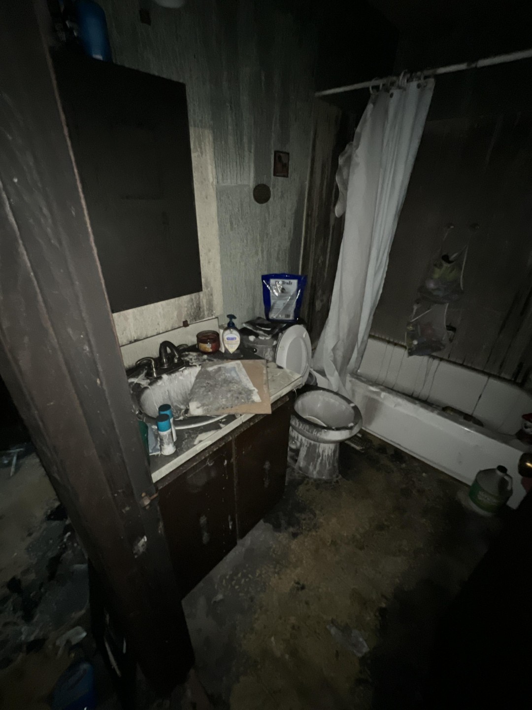 Smoke damaged bathroom with soot residue on walls and fixtures after a house fire