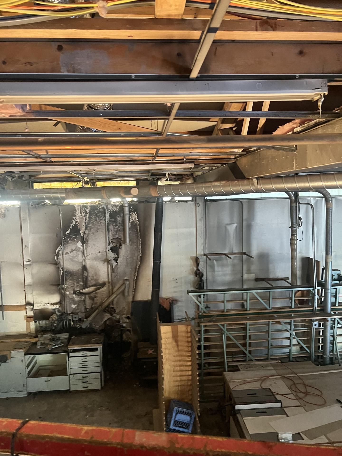 Soot covered walls and charred interior of a fire damaged commercial woodworking shop in Seattle WA before restoration