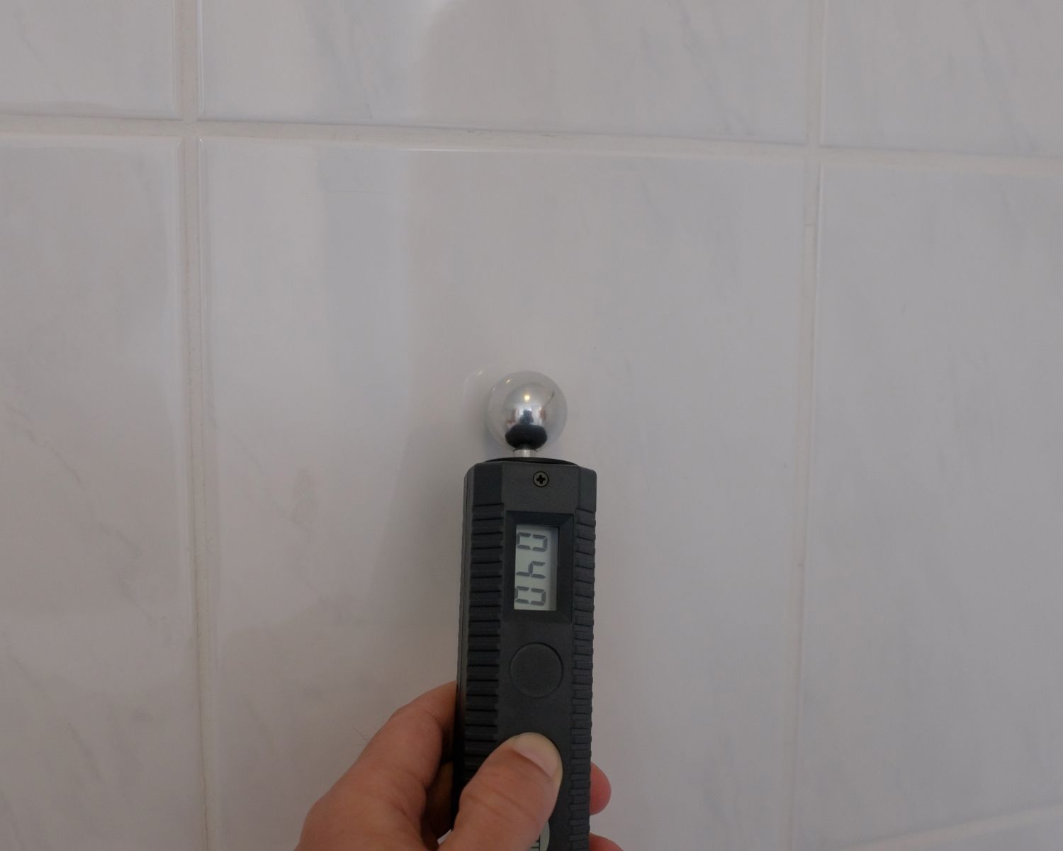 Restoration technician recording a moisture meter reading on a drying log during water damage monitoring in Redmond WA