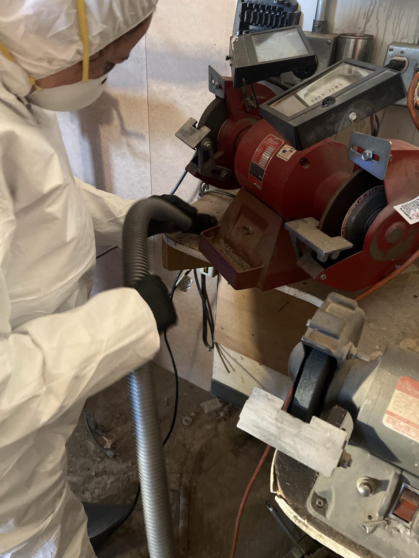 HEPA vacuuming soot from woodworking machinery during fire damage cleanup at a Seattle WA commercial shop