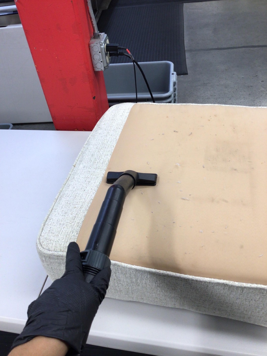 HEPA vacuum extraction removing smoke residue from an upholstered cushion during fire damage contents cleaning