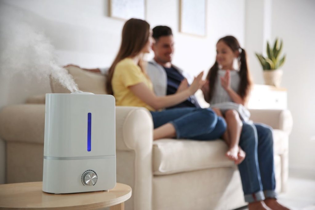 an air purifier and a family of three in the background