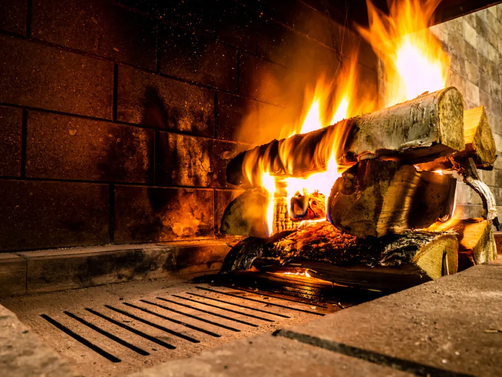 A fire lit on a log in a fireplace