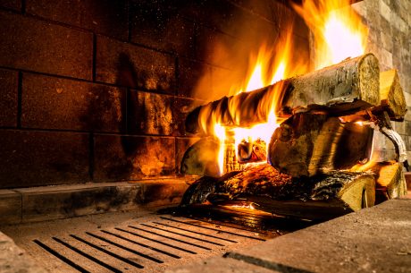 A fire lit on a log in a fireplace
