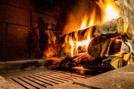 A fire lit on a log in a fireplace