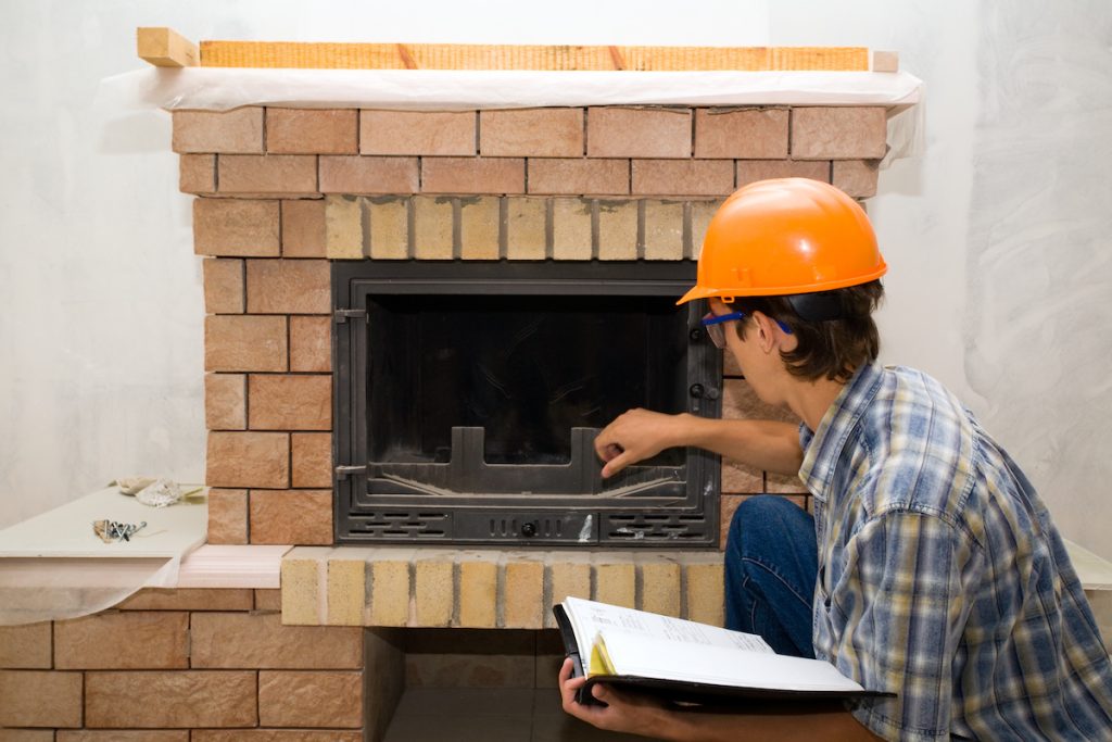 A worker inspects a fireplace to ensure it is functioning properly.