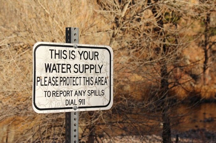 A sign warning people to not dump common water contaminants into the nearby water source