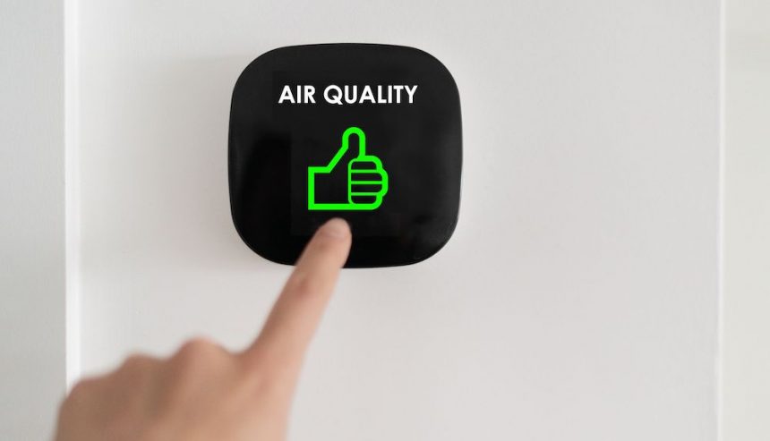 hand adjusting a thermostat for air quality