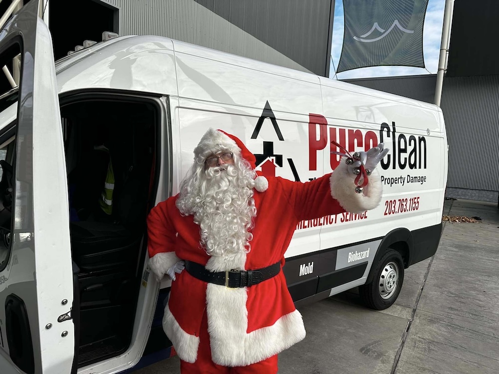 Santa in front of a PuroClean truck at PuroClean in Fairfield, CT