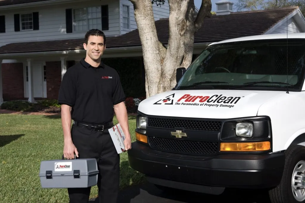 PuroClean technician in front of PuroClean vehicle at customers residential property 
