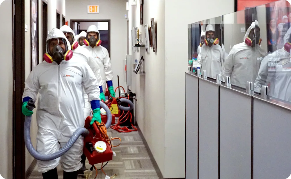 Team of PuroClean technicians in biohazard gear ready to provide biohazard property damage services in a commercial business