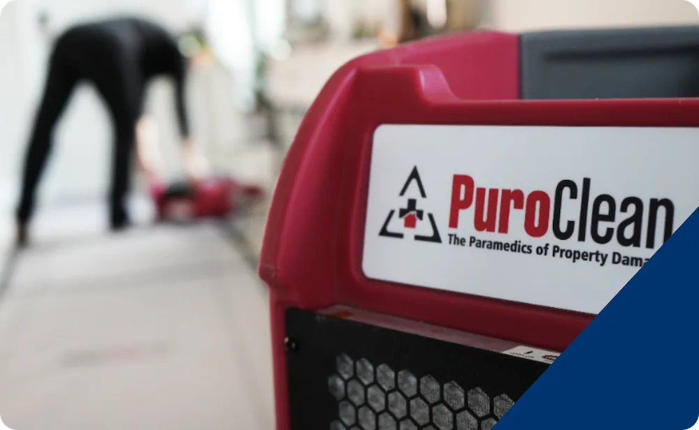 PuroClean branded equipment with a technician blurred in the background