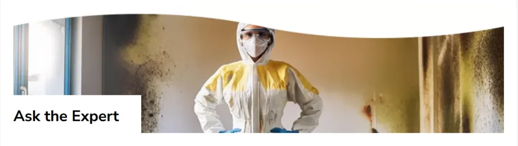 Restoration worker in hazmat suit standing in a damaged room