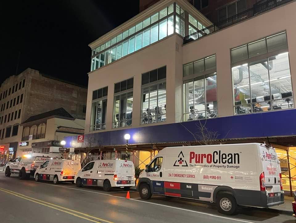 PuroClean vans outside of building during commercial water loss restoration work.